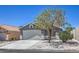 Inviting home with a two-car garage, mature tree, and low-maintenance gravel landscaping at 6456 First View Ave, Las Vegas, NV 89142