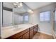 Bathroom with double sinks, stone countertops, and a large mirror, providing ample vanity space at 6564 Baroque Ave, Las Vegas, NV 89139