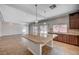 Open kitchen with a large island, wood cabinets, tile floors, and stainless steel appliances at 6564 Baroque Ave, Las Vegas, NV 89139