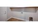 Functional laundry room with tiled floor, shelving, and utility hookups at 6564 Baroque Ave, Las Vegas, NV 89139