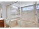 Elegant bathroom with a large tub, glass-enclosed shower, and marble-like tiling at 6564 Baroque Ave, Las Vegas, NV 89139