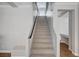 Carpeted staircase featuring a dark handrail and access to an open landing at 6564 Baroque Ave, Las Vegas, NV 89139