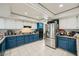 Well-lit kitchen featuring blue and white cabinetry, stainless steel appliances, and granite countertops at 6616 Celeste Ave, Las Vegas, NV 89107