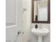 Bathroom with pedestal sink and decorative mirror; new door hardware at 7640 Woven Memories St, Las Vegas, NV 89149