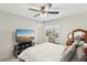 Well-lit bedroom includes ceiling fan, cat tree, television, vanity, and ample natural light from the window at 7640 Woven Memories St, Las Vegas, NV 89149