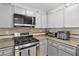 Well-maintained kitchen featuring stainless steel appliances and gray cabinets at 7640 Woven Memories St, Las Vegas, NV 89149