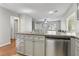 Kitchen features stainless steel dishwasher, gray cabinetry, and flows into the living space at 7640 Woven Memories St, Las Vegas, NV 89149
