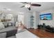 Open living area with a flat screen tv, modern ceiling fan, and combined dining and kitchen at 7640 Woven Memories St, Las Vegas, NV 89149
