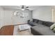 Open living area with a gray sectional, modern ceiling fan, and hardwood floors at 7640 Woven Memories St, Las Vegas, NV 89149