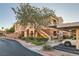 Condo exterior featuring lush landscaping, covered parking, and a well-maintained facade under a sunny sky at 830 Carnegie St # 512, Henderson, NV 89052