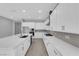 Bright kitchen features white cabinets, stainless appliances, an island and modern countertops at 851 Klamath Springs St, Henderson, NV 89011