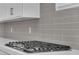 Close-up on new gas range installed on white quartz countertops and gray tile backsplash at 851 Klamath Springs St, Henderson, NV 89011
