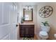 Cozy powder room with dark wood cabinet and granite countertop plus decorative compass wall art at 8605 Trianon Ln, Las Vegas, NV 89145
