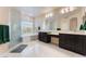 Elegant bathroom featuring a soaking tub, glass-enclosed shower, dual vanities, and modern lighting fixtures at 8605 Trianon Ln, Las Vegas, NV 89145