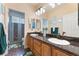 Bathroom features a double sink vanity, framed mirrors and a glass enclosed shower at 8605 Trianon Ln, Las Vegas, NV 89145