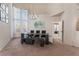 Bright dining room featuring large windows, a modern chandelier, and a sleek dining set at 8605 Trianon Ln, Las Vegas, NV 89145