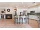 Open kitchen with granite counters, stainless appliances, central island with bar seating, and seamless flow to the fireplace at 8605 Trianon Ln, Las Vegas, NV 89145