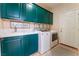 Convenient laundry room featuring bright cabinetry, utility sink, and modern washer and dryer at 8605 Trianon Ln, Las Vegas, NV 89145