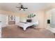 Expansive primary bedroom featuring a ceiling fan, a king bed, and an ensuite bathroom with a glass-enclosed shower at 8605 Trianon Ln, Las Vegas, NV 89145
