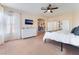Bright primary bedroom featuring a ceiling fan, large windows, and a glimpse of a well-organized office area at 8605 Trianon Ln, Las Vegas, NV 89145
