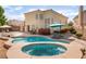 Backyard oasis featuring a refreshing pool and hot tub with lounge seating and mature landscaping at 8605 Trianon Ln, Las Vegas, NV 89145