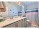Stylish bathroom features a double vanity, a shower with a decorative curtain, and tasteful floral accents at 9440 Lunar Ray St, Las Vegas, NV 89143