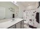 Charming bathroom with a single sink vanity, a large mirror, and a floral shower curtain, creating a serene atmosphere at 9440 Lunar Ray St, Las Vegas, NV 89143