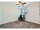 Neutral bedroom boasts carpet flooring, a ceiling fan, and a window offering natural light, perfect for a home office setup at 9440 Lunar Ray St, Las Vegas, NV 89143