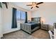 Well-lit bedroom with carpet, a ceiling fan, and a beautifully styled bed with matching nightstand at 9440 Lunar Ray St, Las Vegas, NV 89143