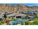 Beautiful backyard with a sparkling pool, manicured lawn, and comfortable patio seating, ideal for relaxation at 9972 Terrastone Dr, Las Vegas, NV 89148
