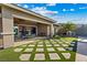 Inviting backyard with a covered patio, outdoor dining area, lush lawn, and a charming playhouse at 9972 Terrastone Dr, Las Vegas, NV 89148
