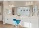 Bright bathroom boasts dual sinks, a large mirror, vanity, and a comfortable seating area at 9972 Terrastone Dr, Las Vegas, NV 89148