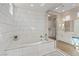 Luxurious bathroom featuring a soaking tub with elegant tile surround and spacious vanity with sleek countertops at 9972 Terrastone Dr, Las Vegas, NV 89148