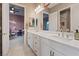 Bathroom with dual sinks and a large mirror, offering a view to the bedroom beyond at 9972 Terrastone Dr, Las Vegas, NV 89148