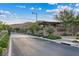 Well-manicured Onyx Point entrance showcasing stone walls, lush greenery, and a paved street leading into the community at 9972 Terrastone Dr, Las Vegas, NV 89148
