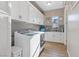 Well-organized laundry room with modern washer, dryer, utility sink and ample storage at 9972 Terrastone Dr, Las Vegas, NV 89148