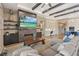 Open-concept living room features a cozy fireplace, built-in shelving, and coffered ceilings with exposed beams at 9972 Terrastone Dr, Las Vegas, NV 89148
