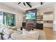 Cozy living room featuring a fireplace, mounted TV, comfortable seating, and access to the backyard at 9972 Terrastone Dr, Las Vegas, NV 89148