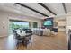 Open-concept living space featuring exposed beams, dining area, living room with fireplace, and a sliding glass door at 9972 Terrastone Dr, Las Vegas, NV 89148