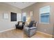 Cozy living room featuring two comfortable armchairs, modern art, and lots of natural light from dual windows at 9972 Terrastone Dr, Las Vegas, NV 89148