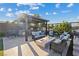 Outdoor kitchen and living area with a built-in grill, fire pit, and comfortable seating, perfect for outdoor gatherings at 9972 Terrastone Dr, Las Vegas, NV 89148