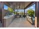 Entertain in this covered outdoor kitchen complete with a stainless steel BBQ, sink, and seating area at 9972 Terrastone Dr, Las Vegas, NV 89148