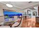 Elegant dining room with glass table, wood floors, and sliding glass doors to patio with city view at 10621 Tinta Ln, Las Vegas, NV 89144