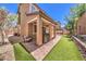 Inviting backyard with a stone patio, grill, artificial grass, and charming outdoor seating at 10961 Winter Rise St, Las Vegas, NV 89141