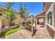 Landscaped backyard with stone perimeter, swing seating and paved patio offering a relaxing outdoor space at 10961 Winter Rise St, Las Vegas, NV 89141