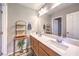 Bathroom with double sinks, wood cabinets, a large mirror, and decorative shelves for a luxurious feel at 10961 Winter Rise St, Las Vegas, NV 89141