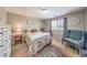 Cozy bedroom with a queen-sized bed, accent chair, and a classic clock on the wall at 10961 Winter Rise St, Las Vegas, NV 89141