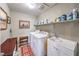 Convenient laundry room featuring a washer, dryer, sink, and shelving for easy organization at 10961 Winter Rise St, Las Vegas, NV 89141