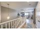 Open-concept living area featuring wood floors, a white banister, and modern lighting fixture at 10961 Winter Rise St, Las Vegas, NV 89141