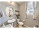 Cozy powder room features a pedestal sink, round mirror and a window for natural light at 10961 Winter Rise St, Las Vegas, NV 89141